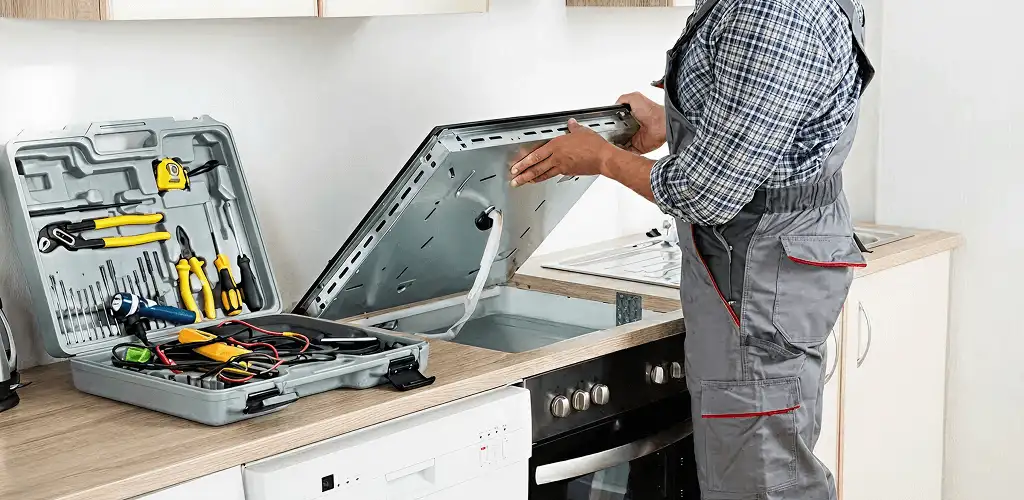 Handyman repairing a cooktop and checking wiring connections in Glendale, AZ