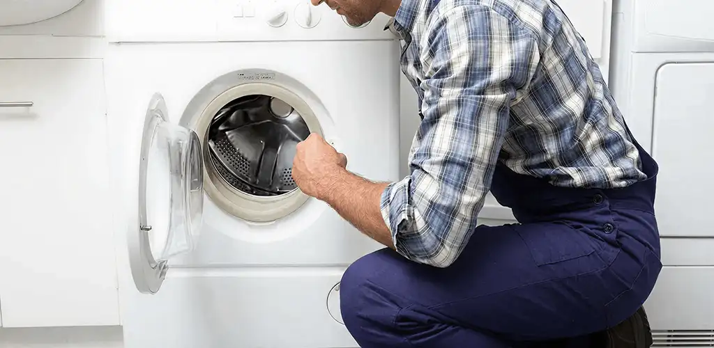 Handyman inspecting a dryer drum and internal parts for repair in Glendale, AZ