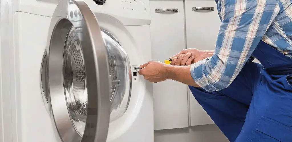 Handyman repairing a clothes dryer and checking electrical connections in Glendale, AZ