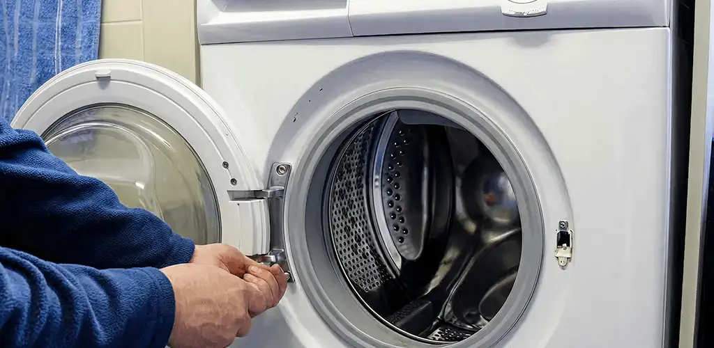 Washing machine repair handyman checking a front-load washer door and latch in Glendale, AZ