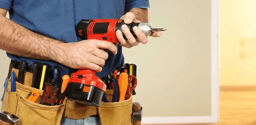 Handyman holding a power drill for home repairs and installations in Glendale, AZ