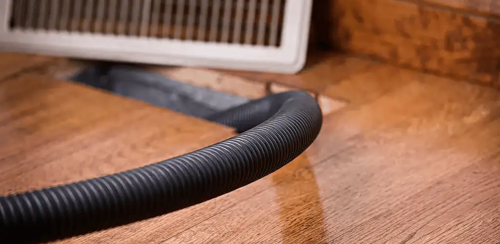 Air duct cleaning hose inserted into a floor vent for ductwork cleaning in Glendale, AZ