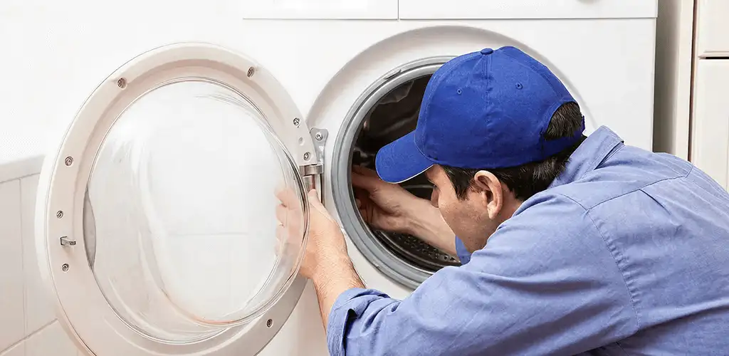 Washing machine repair handyman inspecting a front-load washer drum in Glendale, AZ