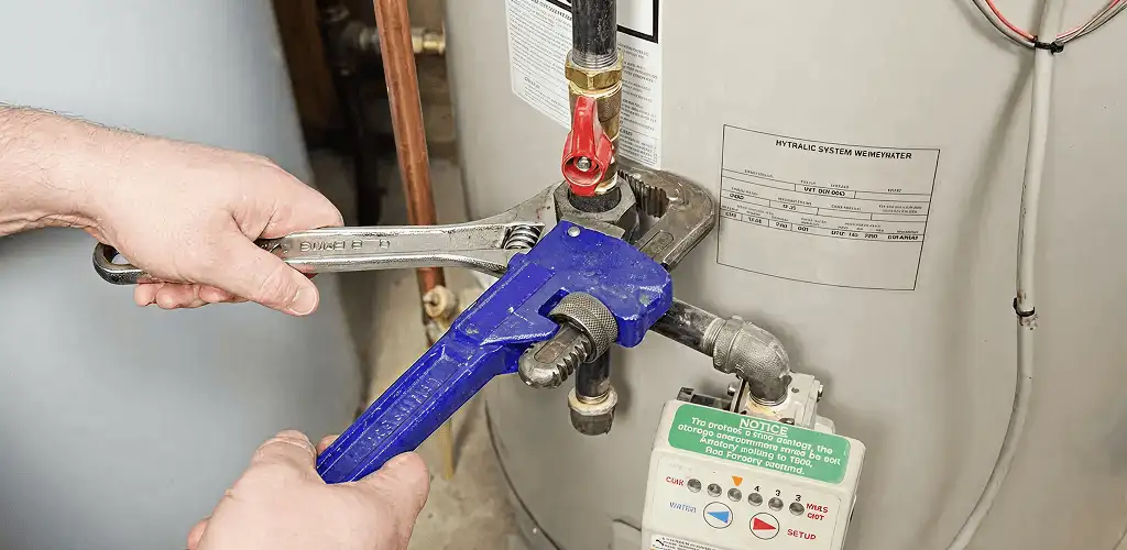 Water heater repair technician tightening the shutoff valve and supply line in Glendale, AZ